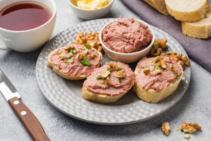 Breakfast on the table. Chicken pate and butter sandwiches. Cup of tea