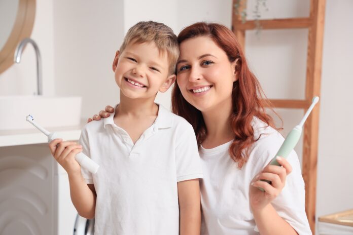 Happy,Mother,And,Her,Little,Son,With,Electric,Toothbrushes,In